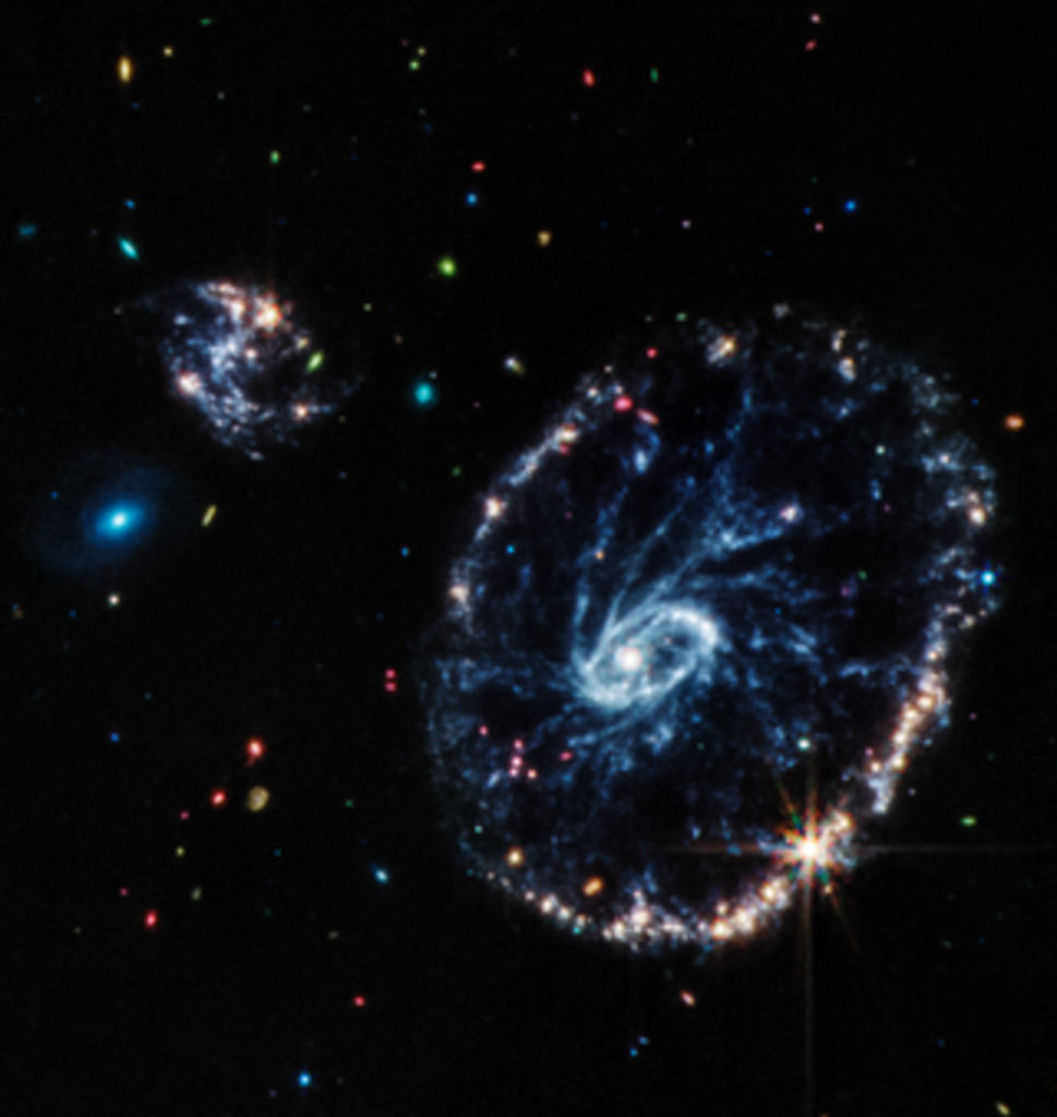 This image from Webb’s Mid-Infrared Instrument (MIRI) shows a group of galaxies, including a large distorted ring-shaped galaxy known as the Cartwheel. The Cartwheel Galaxy, located 500 million light-years away in the Sculptor constellation, is composed of a bright inner ring and an active outer ring. While this outer ring has a lot of star formation, the dusty area in between reveals many stars and star clusters. Credits: NASA, ESA, CSA, STScI, Webb ERO Production Team Download the full-resolution, uncompressed version and supporting visuals from the Space Telescope Science Institute