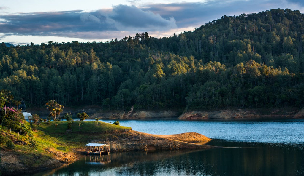 AI caption: a lake surrounded by trees and a house, landscape