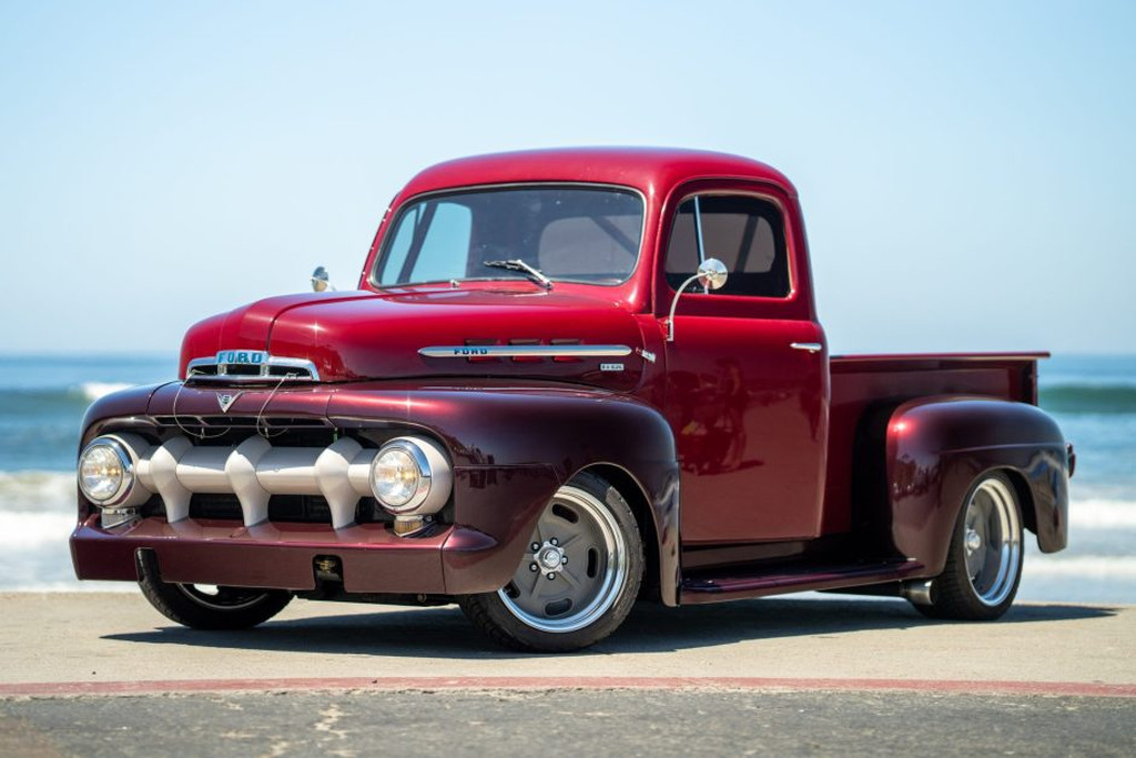 AI caption: a red vintage truck parked on the beach, old fashioned