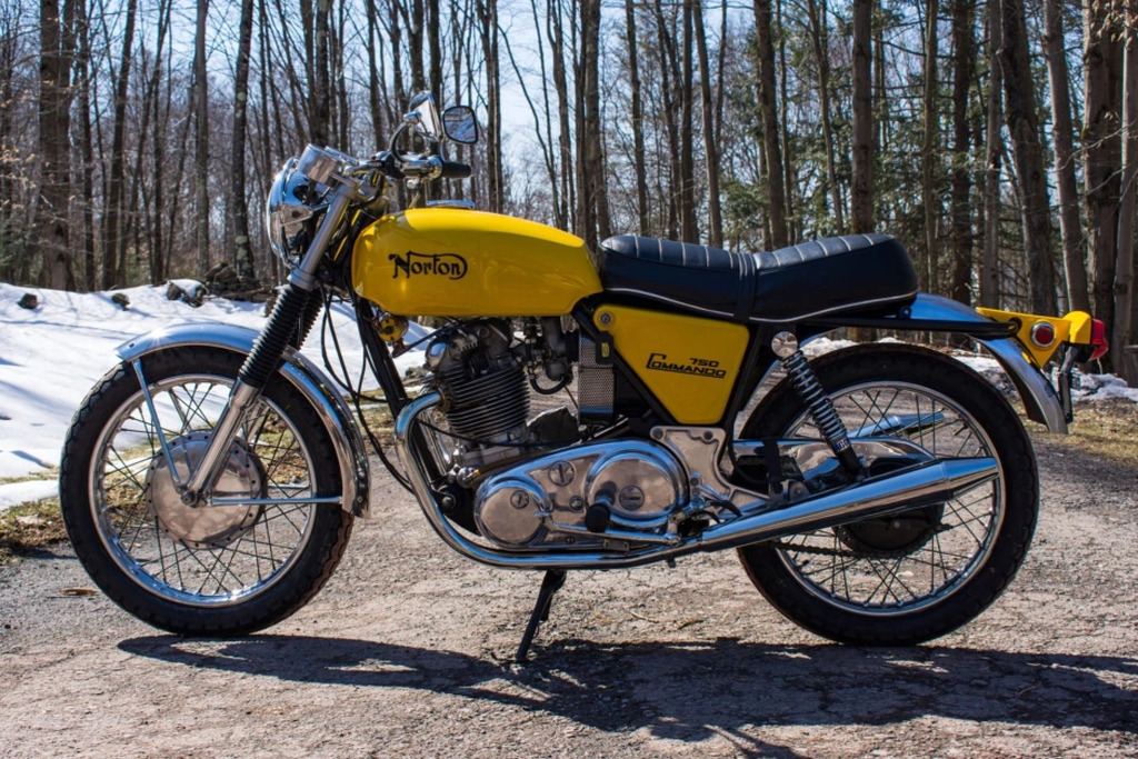 AI caption: a yellow motorcycle parked on a dirt road, vintage