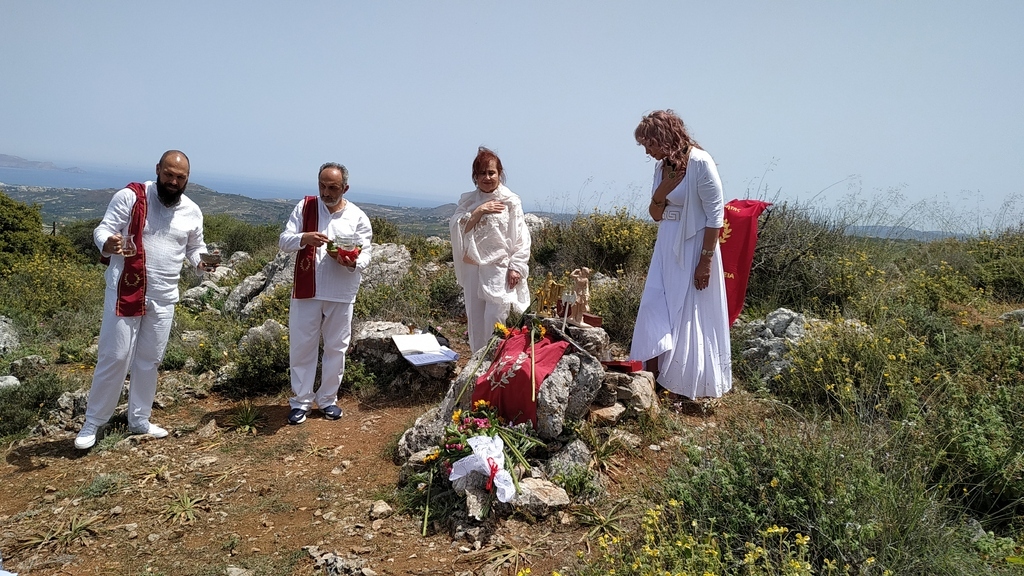 AI caption: the woman is laying flowers on a grave, the woman is dressed in white and the man is dressed in black, religious