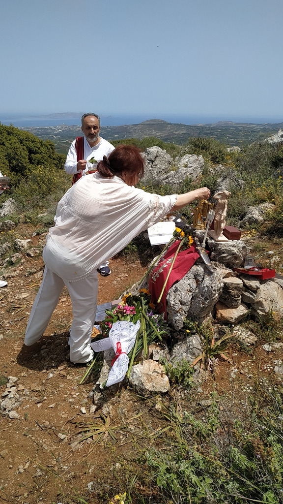 AI caption: a group of people standing on a hill with flowers, portrait a woman is laying flowers on a hillside