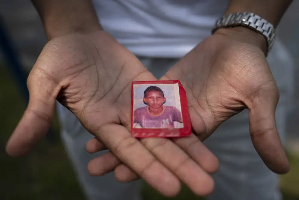 AI caption: a boy holds a photo of a child in his hands, portrait