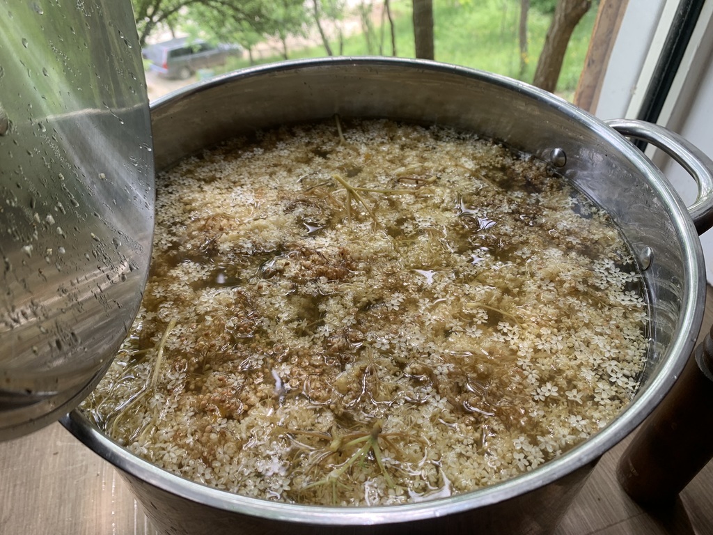 AI caption: a basket of dried elderflowers, a close up of a basket of flowers a pot of water with a lot of grains in it