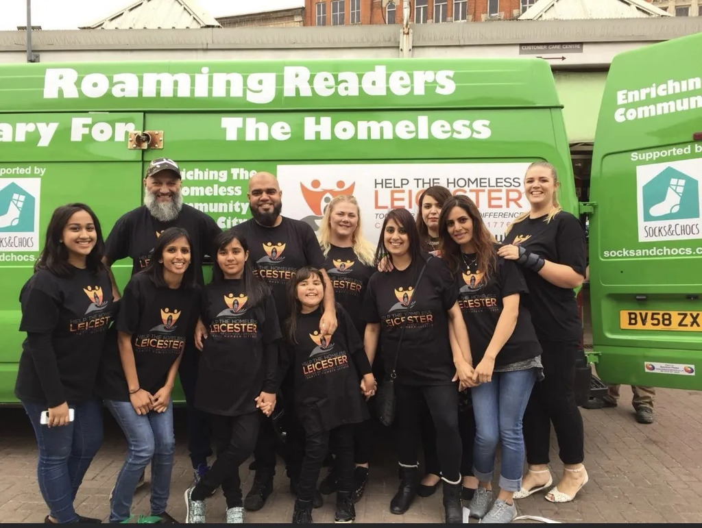 AI caption: a group of people standing in front of a green van with the words reaming readers, group portrait