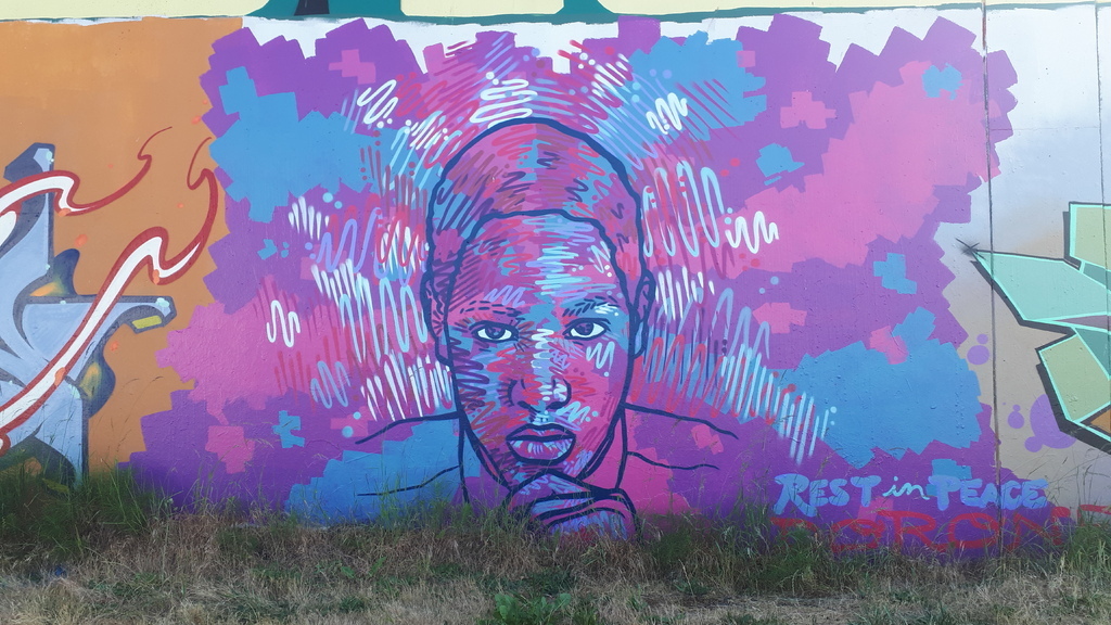 AI caption: a graffiti wall with a man's face on it, graffiti