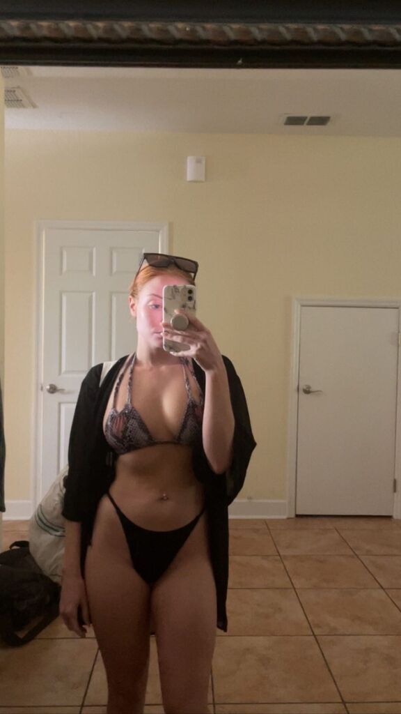 AI caption: a woman in a black bikini taking a selfie, portrait