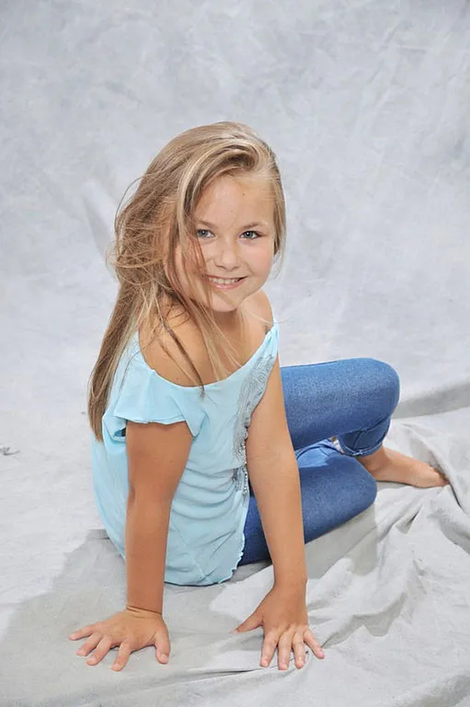 AI caption: a young girl with her hands on her face, portrait a young girl sitting on a white background