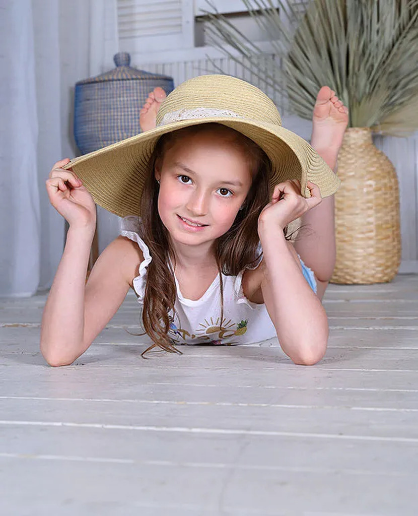 AI caption: a girl laying on the floor with a hat, portrait