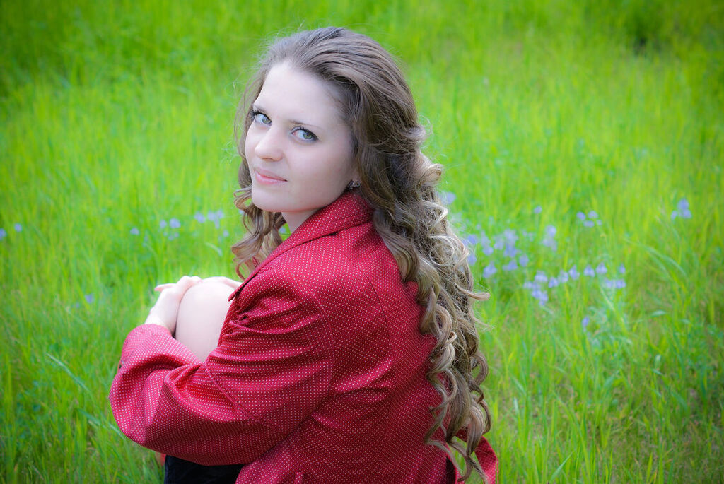 AI caption: a woman sitting on a rock, portrait a young woman in a red jacket sitting in a field